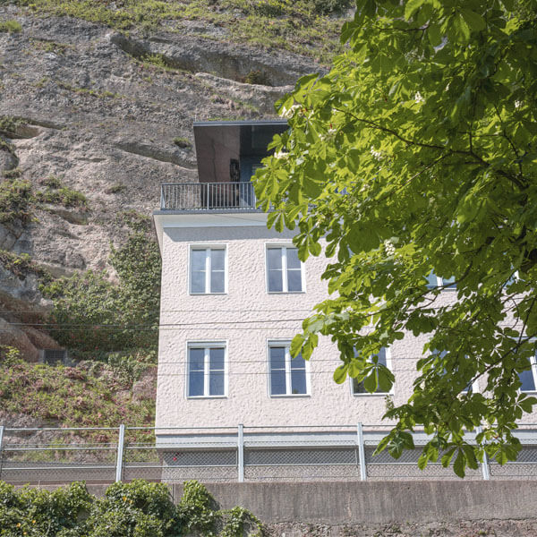 Außenansicht auf den Balkon des vollverglasten Penthouses und den Mönchsberg